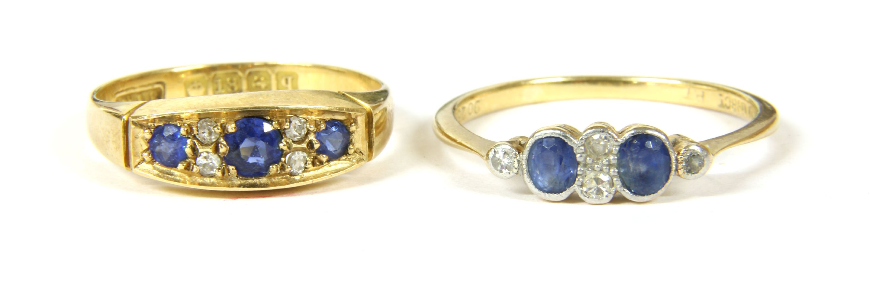 An 18ct gold three stone sapphire ring, with pairs of diamond set points, size M½, 2.83g, and a gold