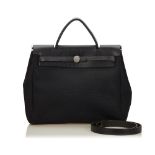 A Hermès Herbag MM handbag, featuring a canvas body, a top leather handle, flat leather shoulder
