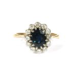 A gold sapphire and diamond cluster ring, to chenier shoulders and a plain polished shank (tested as