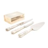 A silver cigarette box, hallmarked, and three silver handled items of cutlery