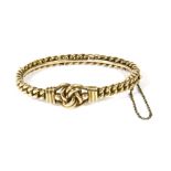 A late Victorian gold hinged bangle, with a central knot motif to a curb link bangle, marked 15,