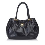 A Prada black leather handbag, featuring a leather body, rolled handles, a top magnetic closure, and