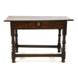 An 18th century oak and walnut side table, the single drawer, on baluster turned supports and square