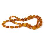 A single row graduated olive shaped amber bead necklace, 12.98g