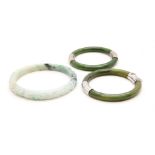 A Chinese jade bangle, carved with foliage, and two other plash bangles