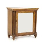 A Regency period mahogany dwarf cabinet, with single mirrored door, flanked by turned columns