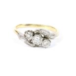 A gold three stone diamond crossover ring, marked 18ct and PLAT (misshapen shank) size K