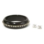 A Dolce and Gabbana black resin bangle, set with white Swarovski crystals to the centre, in dust