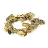 A 9ct gold curb link charm bracelet, with a large amount of assorted charms to include a 9ct gold