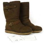 A pair of Ugg boots, dark brown sheepskin, mid-length with buckle detail and flat sole, size 7