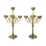 A pair of Gothic brass five-light candelabrum, with foliate scrolled arms, twist turn columns and