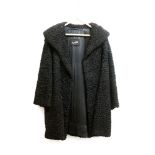 An Astrakhan mid-length coat, with black satin lining with Karter labels