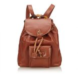 A Gucci Bamboo Calfskin drawstring backpack, featuring a tan calfskin leather body, flat back