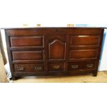 An 18th century oak mule chest, the hinged cover over a central arched panel, with three small