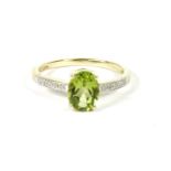 A 9ct gold single stone oval cut peridot ring, with diamond set shoulders, size M, 1.75g