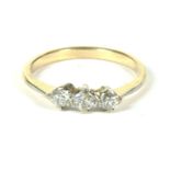 A gold three stone diamond ring claw set to tapering shoulders and a plain polished shank 2.18g size