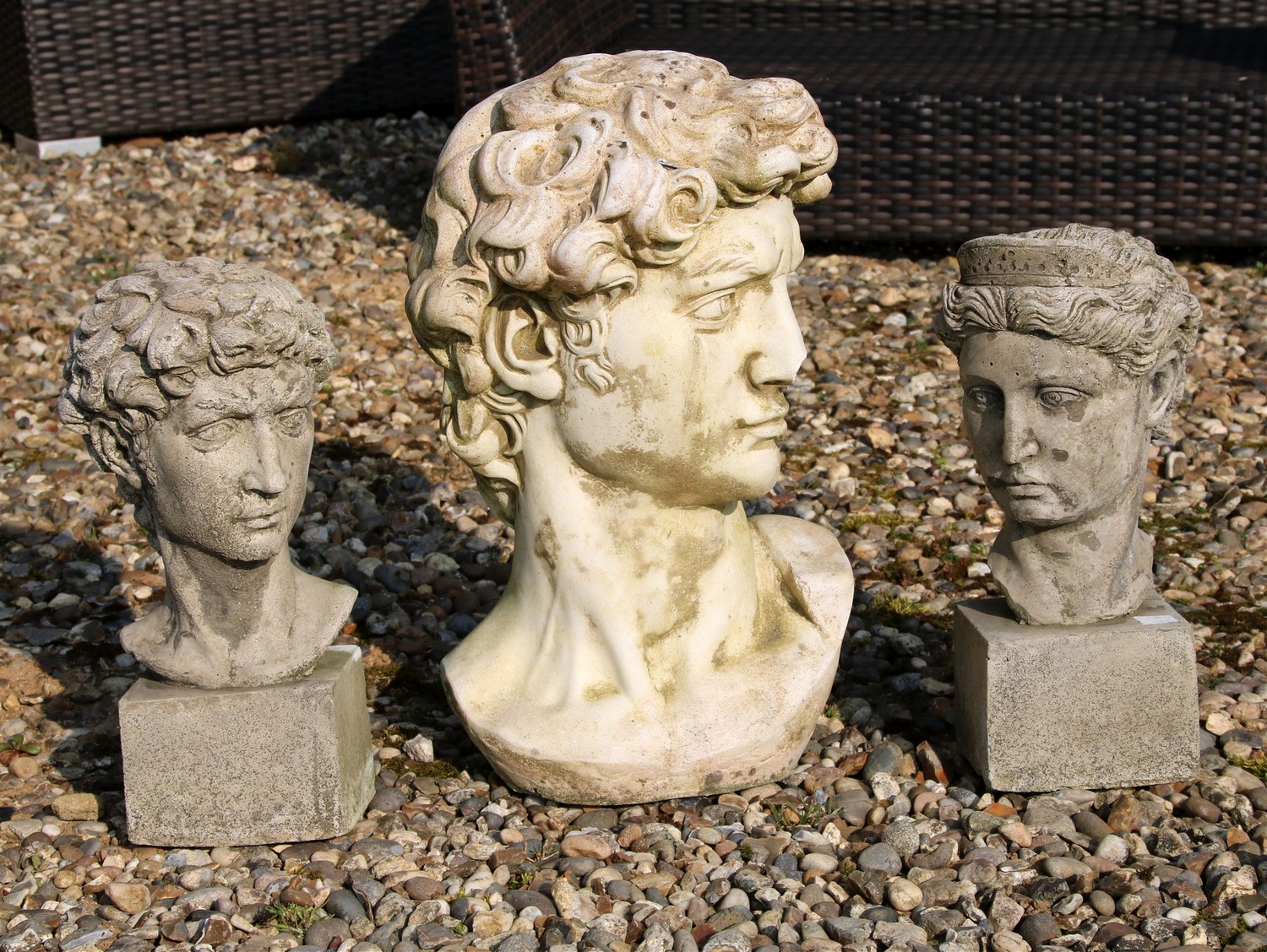 A pair of garden busts depicting classical maiden and companion plinth bases