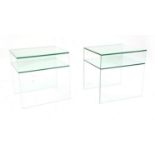 A pair of modern glass two tier side tables