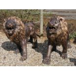 A pair of bronze garden statues modelled as a pair of life size roaring lions, 150cm long, 110cm