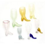 A collection of glass boot form stirrup cups, early 19th Century and later, to include milk glass,