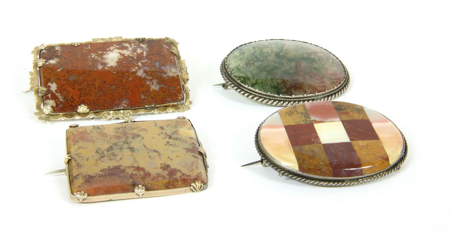 Four Victorian agate brooches, comprising a rolled gold rectangular moss agate brooch, a silver oval