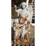A white painted figural group of an angel with a child