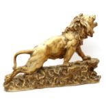 A 1960's resin figure of a roaring lion on a rocky outcrop