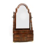 An early 18th century walnut toilet mirror, the dome shaped adjustable plate above arrangement of