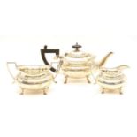 A George V silver batchelor's three piece tea set of faceted form and on short hoof feet