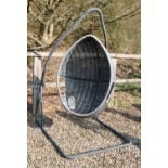 A contemporary wicker egg form garden swing chair