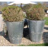 A pair of faux steel planters of tapering cylindrical form