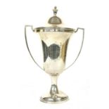 A silver trophy and cover,