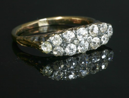 An Edwardian two row diamond boat shaped carved head ring