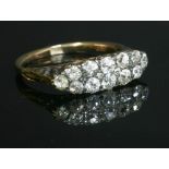 An Edwardian two row diamond boat shaped carved head ring