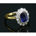 An 18ct yellow and white gold sapphire and diamond oval cluster ring,