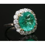 An 18ct white gold emerald and diamond cluster ring,