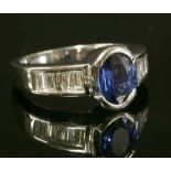 A Continental white gold sapphire and diamond ring with an oval mixed cut sapphire