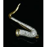 An 18ct yellow and white gold diamond set saxophone brooch,