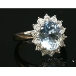 An 18ct white gold aquamarine and diamond oval cluster ring,