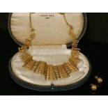 A high carat gold articulated bib style necklace and a pair of matched earrings