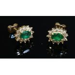 A pair of gold, emerald and diamond oval cluster earrings,