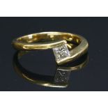 An 18ct gold single stone diamond crossover ring