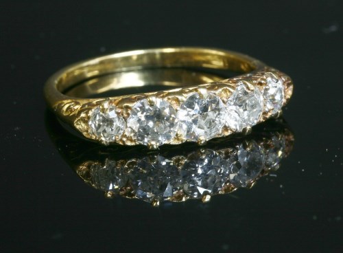 An Edwardian five stone diamond carved head ring