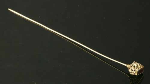 A gold garnet set hat pin