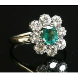 A white gold emerald and diamond cluster ring