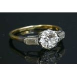 A single stone diamond ring with baguette cut diamonds shoulders,