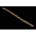 An Edwardian gold and amethyst three bar gate bracelet,