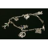 A white gold Art Deco style sapphire, emerald, ruby and diamond set charm bracelet,