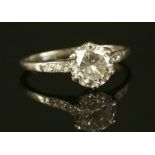 A single stone diamond ring with diamond set shoulders