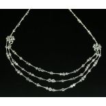 A Continental diamond set three row graduated festoon necklace,